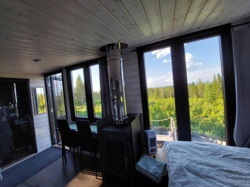 a bedroom with a fireplace and a bed and windows at ReindeerNook in Kuusamo