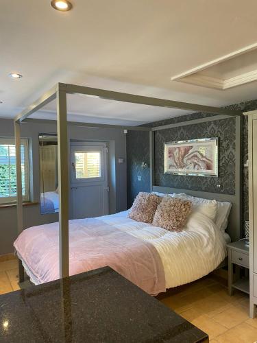 a bedroom with a bed with a canopy at Honeysuckle Cottage - Hillside Holiday Cottages, Cotswolds in Warmington