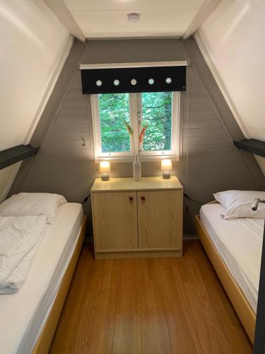 two beds in a small room with a window at Sunclass 206 in Durbuy