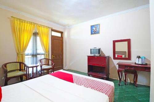 a bedroom with two beds and a desk and a table at Super OYO 90382 Hotel Sarah Sukabumi in Wanasari