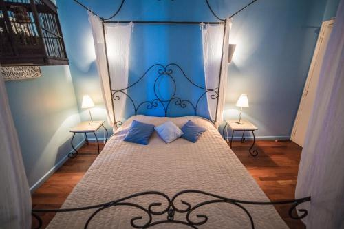 a blue bedroom with a bed with a metal canopy at Mas De Baumes in Ferrières-les-Verreries
