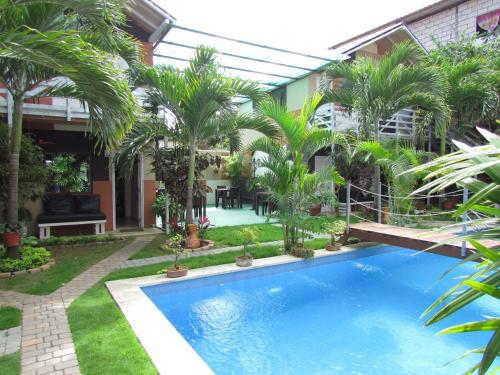a swimming pool in a courtyard with palm trees at Hotel-Restaurante Ancora in Puerto López