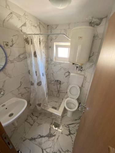 ein weißes Badezimmer mit Toilette und Waschbecken in der Unterkunft Sun-Love in Sutomore