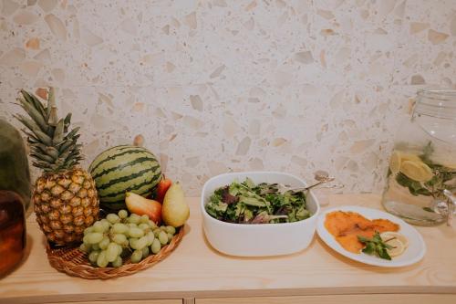 a table with a bowl of fruit and a bowl of salad at CasadoRioHotel in Constância