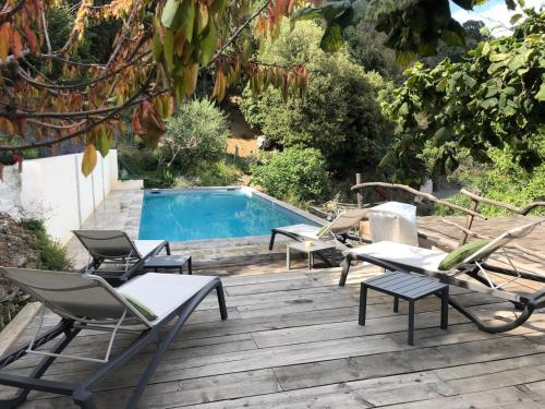 a deck with chairs and a swimming pool at LES CABANES DE LUTINA 