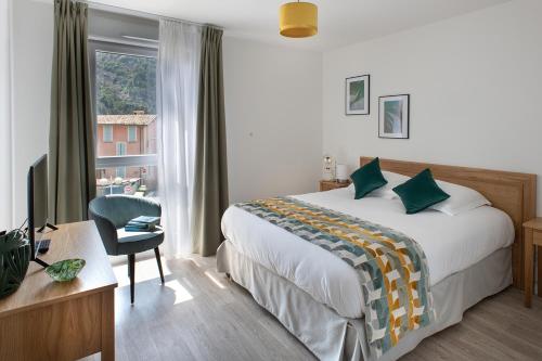 Schlafzimmer mit einem Bett, einem Schreibtisch und einem Fenster in der Unterkunft Résidence services seniors DOMITYS LES EAUX VIVES in Digne-les-Bains