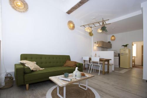 un salon avec un canapé vert et une table dans l'établissement La Ciotat AUTHENTIQUE - T3 à 2 pas du port et des plages - Parking souterrain offert, à La Ciotat