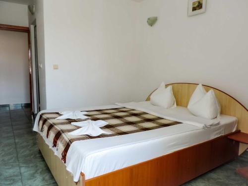 Casa Blanca din COSTINESTI في كوستينيشت: غرفة نوم مع سرير وبطانية مقلية