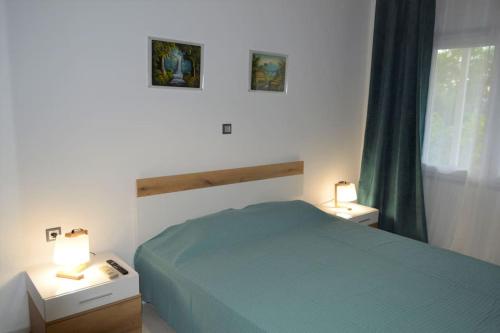 a bedroom with a bed and two night stands with lamps at Litochoro apartment in Estate A1 in Litochoro