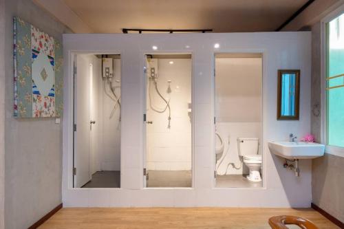 a bathroom with a shower and a toilet and a sink at Buri Hostel Bangkok in Amphoe Phra Khanong