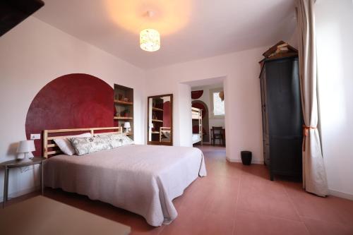 a bedroom with a large bed with a red headboard at Il Mallo Verde - Lake Como B&B in Mandello del Lario