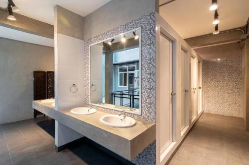 un bagno con due lavandini e un grande specchio di Buri Hostel Bangkok a Amphoe Phra Khanong