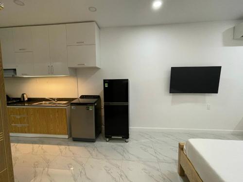a kitchen with a refrigerator and a tv on the wall at Hotel,Căn Hộ Mũi Né Sea link in Phan Thiet