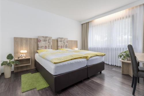 a bedroom with a large bed and a desk at Landgasthaus Berns De Bakker in Engden