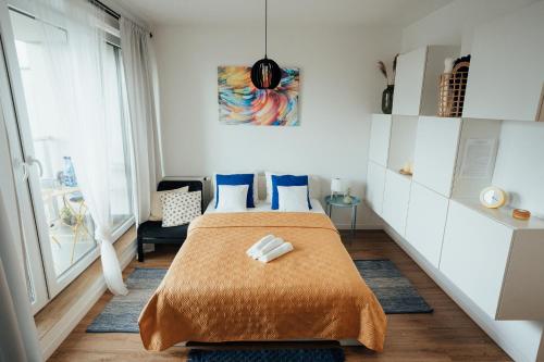 Schlafzimmer mit einem Bett mit orangefarbener Bettwäsche und blauen Kissen in der Unterkunft Blue_Loft in Sandomierz