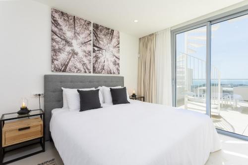 een witte slaapkamer met een groot bed en een groot raam bij Luxury Penthouse Large Terrace 2 Bedrooms OR79 by AORASTAY in La Cala de Mijas