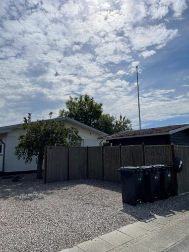 a house with a fence and two trash cans at Holiday home Als in Augustenborg
