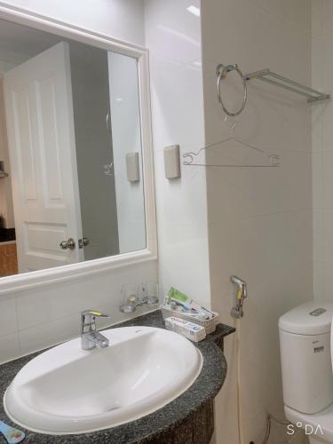 a bathroom with a sink and a mirror and a toilet at Hotel,Căn Hộ Mũi Né Sea link in Phan Thiet
