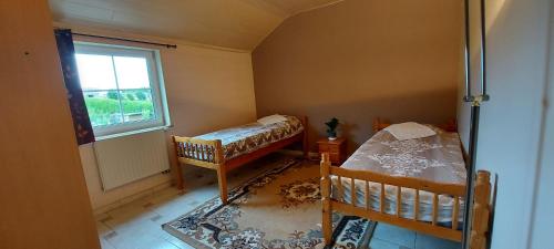 una piccola camera con due letti e una finestra di Nazareth logement Un Magnifique logement de vacances a Bastogne