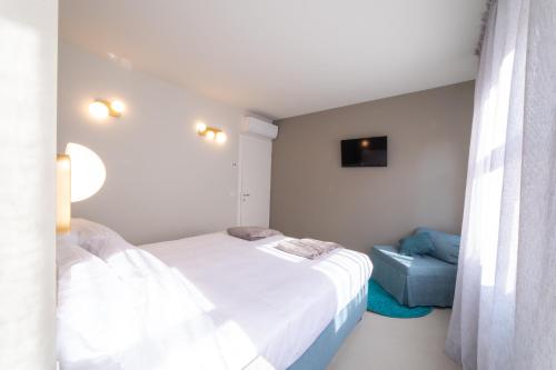 a bedroom with two beds and a blue chair at Casa Agnese in Alba