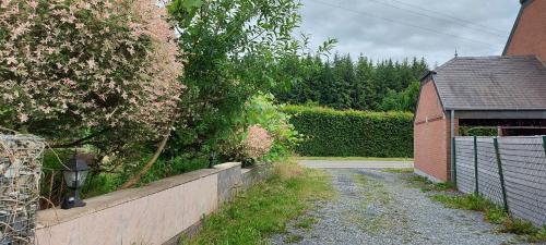 a road leading to a house with a fence at Nazareth logement Un Magnifique logement de vacances in Bastogne