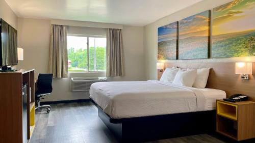 Habitación de hotel con cama y ventana en Days Inn by Wyndham Columbus IN, en Columbus
