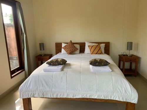 a bedroom with a white bed with pillows on it at Wonder-Land Villa in Ubud