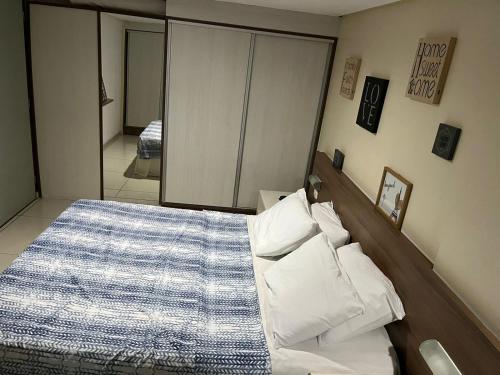 una camera da letto con un letto e un grande specchio di Flat beira mar Tambaú a João Pessoa