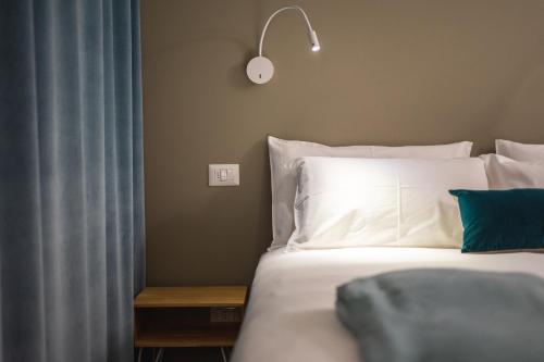 a bedroom with a bed with white sheets and pillows at Casa Agnese in Alba