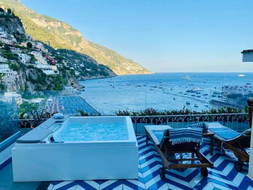 a hot tub on a balcony with a view of the ocean at Villa Diamond Luxury Suite in Positano