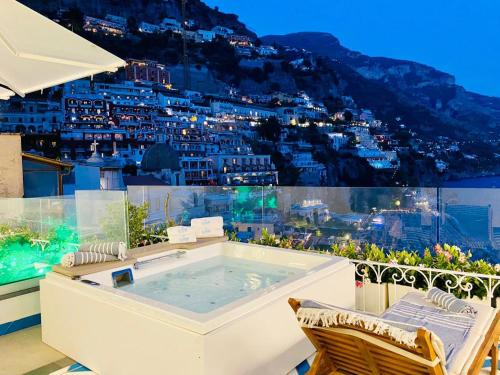 a hot tub on a balcony with a view of a city at Villa Diamond Luxury Suite in Positano