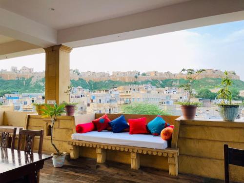 a bench with colorful pillows on a balcony at Golden Marigold Hotel in Jaisalmer