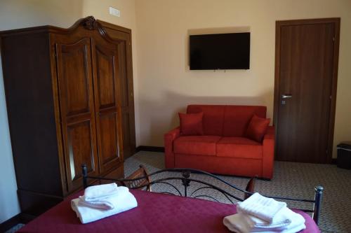 a living room with a red chair and a red couch at La Stazione in Piazza Armerina