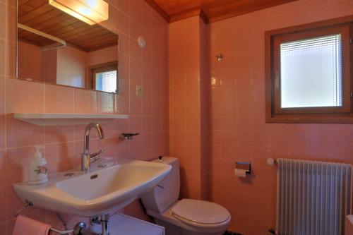 y baño con lavabo, aseo y espejo. en Appartement Les Cascades, en Château-d'Oex