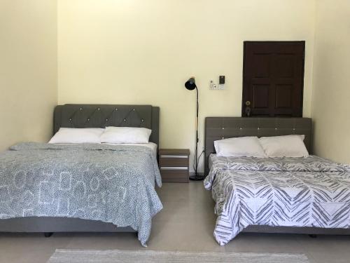 dwa łóżka siedzące obok siebie w sypialni w obiekcie One-Room Homestay 81B Muar w mieście Muar