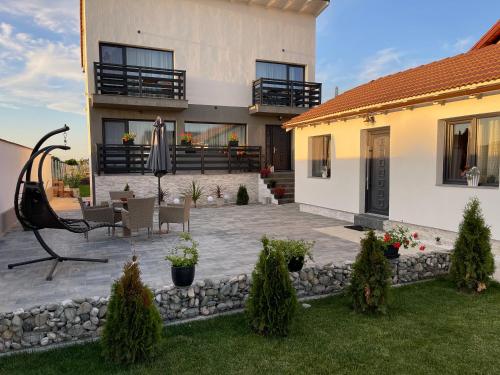 a house with a patio with an umbrella in the yard at Casa Valentina in Cristian