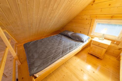 a bedroom with a bed in a wooden cabin at Kotwicownia in Mikołajki