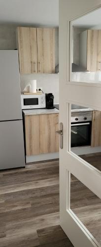 een keuken met houten kasten en een witte koelkast bij Tenerias 2 in Castellón de la Plana