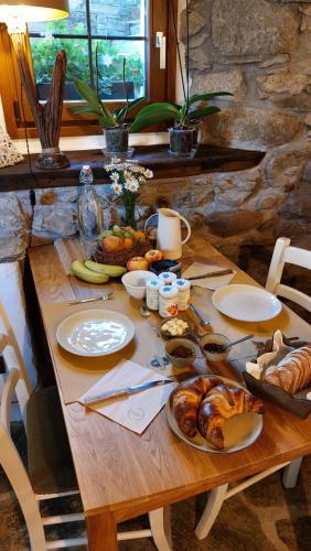 una mesa de madera con pan y bollería. en BeB LUCA76 en Avise