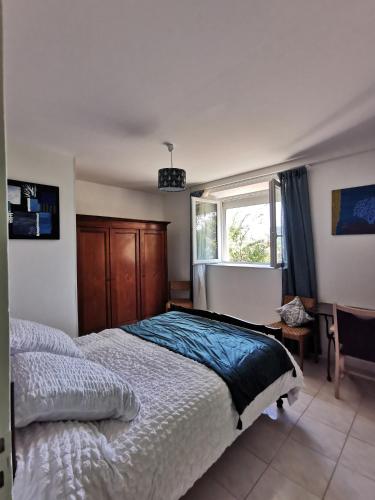 une chambre avec un grand lit et une fenêtre dans l'établissement Appartement dans maison individuelle LE CAYLUS BAS, à Saint-Affrique
