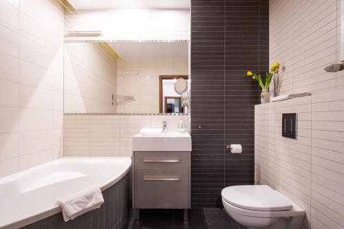 La salle de bains est pourvue d'un lavabo, de toilettes et d'une baignoire. dans l'établissement Gama Home Wyspowa 1, à Varsovie