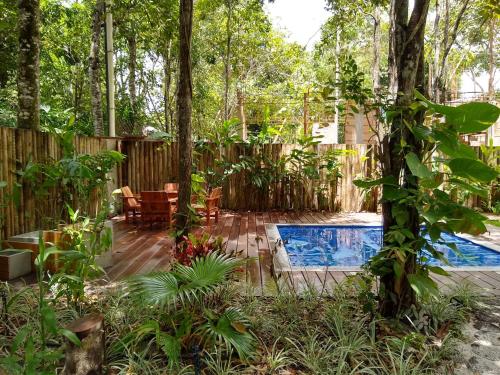 a backyard with a pool and a wooden fence at Casa Gungalilin Trancoso in Trancoso