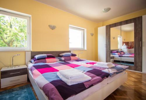 a bedroom with a large bed and a mirror at Studio apartman Second Serve in Samobor
