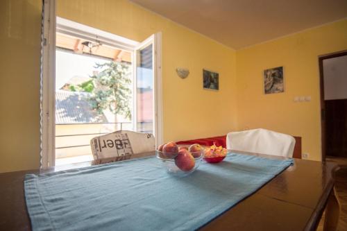 a dining room table with two bowls of fruit on it at Studio apartman Second Serve in Samobor