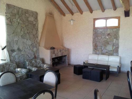 a living room with a fireplace and a stone wall at Tierras Blancas Nihuil in El Nihuil