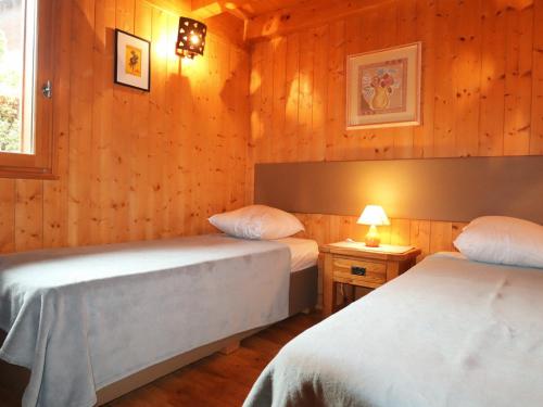 Duas camas num quarto com paredes com painéis de madeira em Appartement Samoëns, 4 pièces, 6 personnes - FR-1-624-25 em Samoëns