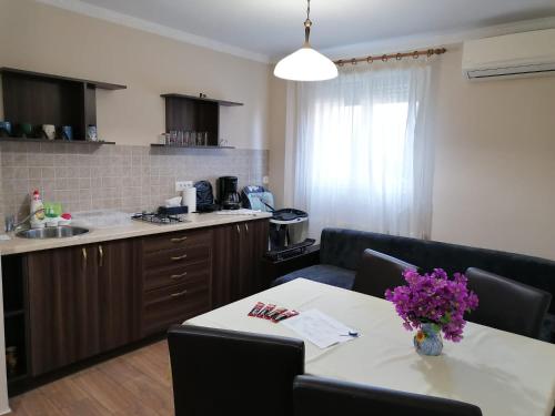 a kitchen with a table with a vase of flowers on it at Apartament Alena in Baile Felix