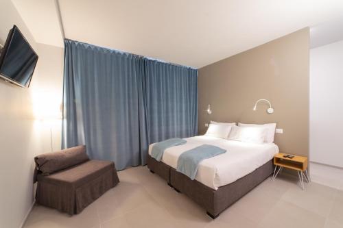 a hotel room with a bed and a chair at Casa Agnese in Alba