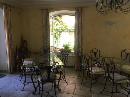 une salle à manger avec une table et des chaises et une fenêtre dans l'établissement La Pierre Bleue / Chambres d'hôtes, à Saint-Martin-Vésubie