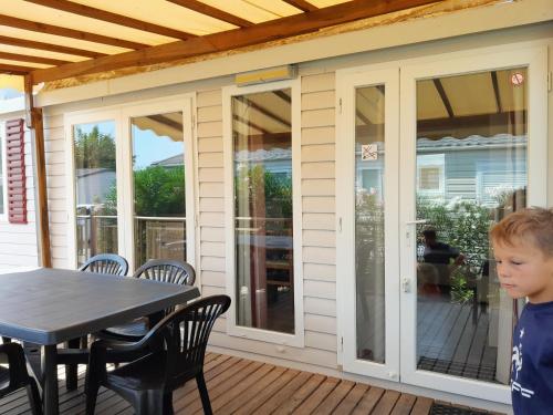 a little boy standing on a patio with a table at Grand mobilhome spacieux 8 places frejus/straphael in Fréjus